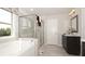 Bright bathroom with granite counters, large mirror, tile flooring, glass-enclosed shower, and soaking tub at 4585 Woodland Bank Blvd, Buford, GA 30518