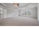 Large bedroom featuring plush carpeting, a ceiling fan, and oversized windows bringing in natural light at 4585 Woodland Bank Blvd, Buford, GA 30518