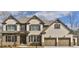 Charming two-story home with a brick and stone facade, complemented by a two-car garage and mature trees at 4585 Woodland Bank Blvd, Buford, GA 30518
