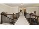 Hallway with carpet flooring and wood-and-wrought iron banister overlooking the staircase at 4585 Woodland Bank Blvd, Buford, GA 30518