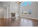Bright and airy living room with a fireplace, hardwood floors, and large windows at 4585 Woodland Bank Blvd, Buford, GA 30518