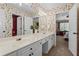 Stylish bathroom featuring wallpaper, large mirror, white cabinetry, double sink vanity, and tiled floors at 9860 Hunt Club Way, Johns Creek, GA 30022