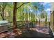 Outdoor deck with grill and dining set, surrounded by mature trees for a private outdoor space at 9860 Hunt Club Way, Johns Creek, GA 30022