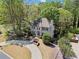 Charming two-story traditional home with a circular driveway and mature landscaping at 9860 Hunt Club Way, Johns Creek, GA 30022