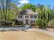 Beautifully landscaped home with a circular driveway and lush greenery surrounding the property at 9860 Hunt Club Way, Johns Creek, GA 30022