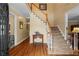 Open foyer featuring hardwood flooring and a staircase with carpeted treads at 9860 Hunt Club Way, Johns Creek, GA 30022