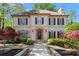 Elegant two-story home featuring a manicured front yard and a stone walkway leading to the arched front door at 9860 Hunt Club Way, Johns Creek, GA 30022