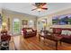 Bright living room featuring hardwood floors, large windows, and an open layout at 9860 Hunt Club Way, Johns Creek, GA 30022