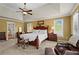 Comfortable main bedroom with a tray ceiling, ceiling fan, and lots of natural light from the windows at 9860 Hunt Club Way, Johns Creek, GA 30022