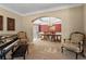 Open floorplan of the piano room, transitioning into the formal dining room with upholstered chairs at 9860 Hunt Club Way, Johns Creek, GA 30022