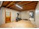 Unfinished basement space with exposed wood beams, door to the outside, and concrete floor at 1477 Brawley Ne Cir, Brookhaven, GA 30319