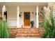 Welcoming front porch with brick steps, decorative plants, and cozy seating, creating a warm entrance at 1477 Brawley Ne Cir, Brookhaven, GA 30319