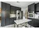 Modern kitchen featuring stainless steel appliances, stylish dark cabinets, and marble countertop island at 1477 Brawley Ne Cir, Brookhaven, GA 30319