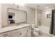 Bathroom featuring a shower-tub combo, granite countertop, white cabinets, and a large mirror at 201 Saddle Rd, Alpharetta, GA 30009