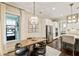 Eat-in kitchen featuring a wooden dining table with modern pendant lighting, a large window, and white cabinets at 201 Saddle Rd, Alpharetta, GA 30009