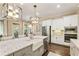 Bright kitchen featuring modern appliances, white cabinets, large island, and stainless steel refrigerator at 201 Saddle Rd, Alpharetta, GA 30009