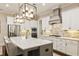 Gourmet kitchen with white cabinets, stone backsplash, and a large island with a gas cooktop at 201 Saddle Rd, Alpharetta, GA 30009