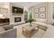 Cozy living room featuring a stone fireplace, a large sectional, and natural light from surrounding windows at 201 Saddle Rd, Alpharetta, GA 30009