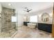 Relaxing main bathroom boasting a glass enclosed shower, and sinks, and a soaking tub under a window at 201 Saddle Rd, Alpharetta, GA 30009