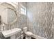 Stylish powder room with patterned wallpaper, a unique mirror, and a pedestal sink at 201 Saddle Rd, Alpharetta, GA 30009
