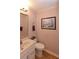Cozy half bathroom featuring a framed painting, decorative mirror, and modern vanity at 2815 Cambridge Hills Rd, Cumming, GA 30041