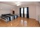 Spacious bedroom with hardwood floors, natural light, and a striped comforter on the bed at 2815 Cambridge Hills Rd, Cumming, GA 30041