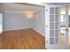 Open room with hardwood flooring leading to the living room with large windows at 2815 Cambridge Hills Rd, Cumming, GA 30041