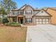 Charming two-story home with brick accents, a two-car garage, and a well-manicured front yard at 3541 Stoneleigh Walk, Lithonia, GA 30038