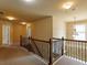 Wide view of a hallway featuring neutral carpet, beige walls, and a wooden railing leading to other rooms at 3541 Stoneleigh Walk, Lithonia, GA 30038