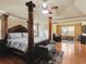 The main bedroom includes hardwood floors, a four-poster bed, and a sitting area for a relaxing space at 3541 Stoneleigh Walk, Lithonia, GA 30038