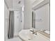 Bathroom featuring white sink and walk-in shower with white tile and gray shower curtain at 3988 Centennial Trl, Duluth, GA 30096