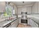 Beautiful kitchen with stainless steel appliances, granite countertops, and gray cabinets at 3988 Centennial Trl, Duluth, GA 30096