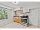 Basement kitchenette with stainless steel appliances, light wood cabinets, and natural light from window at 3988 Centennial Trl, Duluth, GA 30096