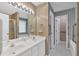 Bright bathroom features a double sink vanity, large mirror, and shower with glass door at 209 Southerness Ct, Stockbridge, GA 30281