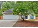 Charming single-story home features a two-car garage, manicured lawn, and inviting entrance with a blue door and blue shutters at 209 Southerness Ct, Stockbridge, GA 30281