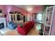 This living room has bright pink walls, wooden floors, and cozy furniture at 209 Southerness Ct, Stockbridge, GA 30281