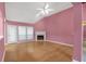 Spacious living room featuring a fireplace, a ceiling fan, and large windows at 209 Southerness Ct, Stockbridge, GA 30281