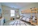 This bedroom offers a wooden bunk bed with a rug and a white accent chair next to a bright window at 2162 Spikerush Way, Buford, GA 30519