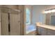 Modern bathroom features a glass-door shower, bathtub, and large vanity with a large mirror at 225 Mountain Vista Blvd, Canton, GA 30115