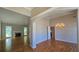 Spacious living room featuring gleaming hardwood floors, a charming fireplace, and an elegant chandelier above the dining area at 225 Mountain Vista Blvd, Canton, GA 30115