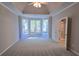 Carpeted bedroom features a tray ceiling, a ceiling fan, and large bright windows at 225 Mountain Vista Blvd, Canton, GA 30115