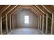 Unfinished attic space with exposed beams and a window, awaiting personalized design and build-out at 225 Mountain Vista Blvd, Canton, GA 30115