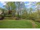 Backyard featuring a large grassy area, trees, and access to a creek at 3025 Kaley Nw Dr, Kennesaw, GA 30152