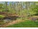 Backyard featuring a creek surrounded by lush greenery at 3025 Kaley Nw Dr, Kennesaw, GA 30152