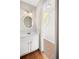 Charming powder room with oval mirror, and hardwood floors leading to the staircase at 3025 Kaley Nw Dr, Kennesaw, GA 30152
