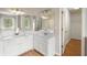 Primary bathroom with dual vanities, large mirrors and hardwood floors, providing ample space and storage at 3025 Kaley Nw Dr, Kennesaw, GA 30152