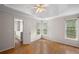 Bright bedroom with tray ceiling, two windows and hardwood floors, offering a view of the ensuite bathroom at 3025 Kaley Nw Dr, Kennesaw, GA 30152