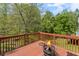 Exterior wooden deck with outdoor fireplace and overlooking the back yard at 3025 Kaley Nw Dr, Kennesaw, GA 30152