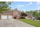 Charming two-story brick home with a well-manicured lawn, mature trees, and an attached two-car garage at 3025 Kaley Nw Dr, Kennesaw, GA 30152