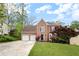 Charming two-story brick home with an attached two-car garage, beautiful shrubs, and a well-manicured lawn at 3025 Kaley Nw Dr, Kennesaw, GA 30152